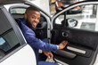 © Prostock-studio - Handsome Young Black Man In Suit Sitting In His New Car And Smiling At Camera, Cheerful African American Male Posing In Luxury Vehicle After Buying Automobile In Modern Dealership Center, Closeup