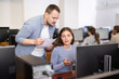 © JackF - Male teacher of computer courses helps girl student to figure out with performance of difficult task, master ark. Mentor observes students studies, looks at monitor screen.