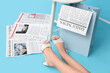 © Pixel-Shot - Legs of woman in high heels with newspapers and shopping bag on blue background