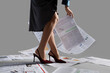 © Pixel-Shot - Young woman in high heels with many newspapers on grey background, closeup