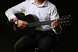 © Pixel-Shot - Young man playing guitar on black background