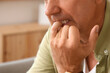 © Pixel-Shot - Worried mature man biting nails at home, closeup