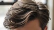 © skything - A close-up view of a man's stylish haircut with layered locks and highlighted strands