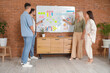 © Pixel-Shot - Group of people with business plan on whiteboard in office