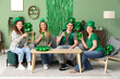 © Pixel-Shot - Group of people drinking beer at home on St. Patrick's Day