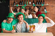 © Pixel-Shot - Group of young people with beer celebrating St. Patrick's Day at table in pub