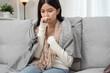 © Shisu_ka - sick woman with a headache sitting under blanket, female sneezing and runny nose with seasonal influenza, allergic, high fever and influenza, resting, virus, coronavirus, feel illness, respiratory