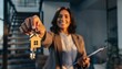 © Rifqi - Smiling female real estate broker holding house keys with wooden keychain indoors, concept for housing market investment, property management and closing transactions