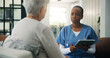 © WesJVR/peopleimages.com - Discussion, patient and caregiver with tablet in home, health evaluation results and medical counseling. Speaking, tech and senior person with nurse for assessment report, support or diagnosis talk