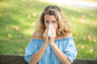 © auremar - sneezing young girl with nose wiper in a park