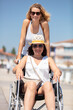 © auremar - invalid girl on the wheelchair with friend outdoors