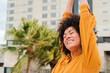 © Jose Calsina - A cheerful young woman stretching her arms wide, expressing her joy and positivity, radiating happiness in every moment, capturing a sense of freedom and delight in her vibrant demeanor.