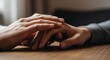 © bigstokk - Two people holding hands on a wooden table