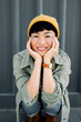 © VISTA by Westend61 - Laughing woman with beanie and casual outfit in urban setting