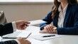© TechNova Graphics - Businessperson handing over an envelope to a woman at a desk in an office setting with a laptop and notebook