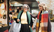 © VictorCanalesStudio - Two cheerful senior women enjoying shopping together at a winter christmas market