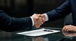 © Alexandr - Business handshake over contract on reflective glass table with pen and hands