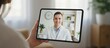 © olga_demina - Person having an online video call with a smiling doctor on a digital tablet, illustrating convenient virtual medical consultation and remote healthcare