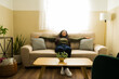 © AntonioDiaz - Young woman relaxing on comfortable sofa at home, feeling happy and peaceful, enjoying comfort in living room