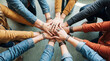 © Glyph Studio - Diverse group of friends and colleagues collaborating together with hands piled in a sign of unity and teamwork on a lightcolored floor