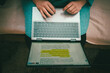 © krsmanovic - Laptop on woman's lap on couch