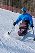 © Alex - A man poses in a special ski bob for wheelchair users