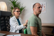 © Nenad - Female middle-aged doctor using stethoscope to examine patient.