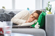 © baranq - Ill woman coughing and feeling unwell lying on sofa during viral infection