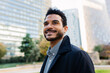 © Xavier Lorenzo - Portrait of smiling young adult Latin American businessman at city park. Warm expression highlighted by natural light in a modern district. Business and people concept.