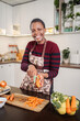 © Jelena - Woman smiling while peeling carrots preparing healthy meal