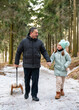 © Alexander - Happy father pulls sled as his little daughter walks next to him in winter forest. Smiling family enjoying joyful outdoor walk, winter lifestyle and bonding.