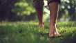 © nur - Barefoot person walking on green grass in sunlight conceptual image