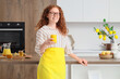 © Pixel-Shot - Young redhead woman with turmeric drink in kitchen