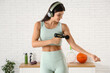 © Pixel-Shot - Sporty young woman using percussive massage device after training in gym