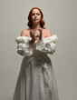 © faestock - close up portrait beautiful redhead female model wearing historical white fantasy wedding dress, fairytale  ball gown, holding crystal seers orb. overhead studio lighting on white background