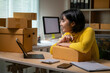 © Wasana - Asian female entrepreneur managing online sales from home office