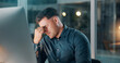 © SparkPix/peopleimages.com - Headache, night or man in office with computer, overworked or stress in missed deadline. Migraine, bokeh or employee in workplace with tech, vertigo or burnout in late shift task management.