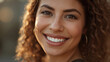 © siraphol - Smiling woman with curly hair and warm sunlight glow, confident friendly portrait