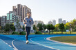 © leungchopan - Young female athlete running on track outdoors