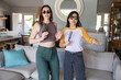 © wavebreak3 - Diverse female friends singing into hairbrushes while wearing sunglasses in open-plan living room