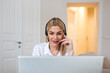 © Graphicroyalty - Professional Female Customer Support Representative Wearing Headset and Working on Laptop. Smiling Woman Consulting Client via Video Call or Online Meeting While Working Remotely from Home Office.