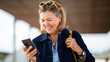 © Paula - Happy senior woman looking at smartphone and laughing outdoors