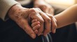 © Muhammad - Elderly person holding hands with a younger person in comfort.