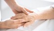 © AspctStyle - Compassionate young hand holding wrinkled senior patient's hand gently in a bright hospital room symbolizing medical care and support.