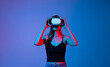 © Volodymyr_sh - Woman using virtual reality headset in blue studio light, immersive VR technology experience, future digital interaction concept