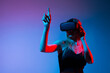 © Volodymyr_sh - Woman using VR headset and pointing upward in virtual space, immersive gesture interaction and futuristic technology concept
