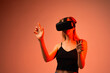 © Volodymyr_sh - Woman navigating virtual reality space using VR headset and expressive hand gestures in futuristic red light studio setting