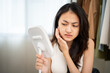 © Chanakon - Worried Asian woman looking at mirror, touching dry irritated skin and acne spots. Female feeling unhappy with wrinkles and face dehydration searching for skincare solution.