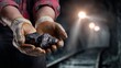 © CreativeArt - Coal mine miner holding precious coal in hands showing fossil fuel energy source from underground excavation industry