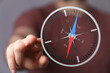 © vegefox.com - Close up of a man's hand pointing towards a compass. Conceptual image for direction, guidance, and navigation. Represents the idea of finding a